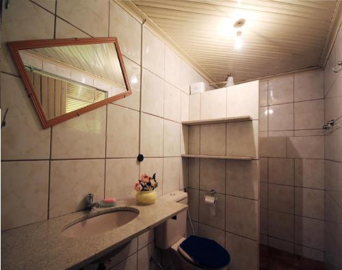 une salle de bain avec un lavabo et un miroir et des toilettes dans l'établissement Casa Pagotto, à Olímpia