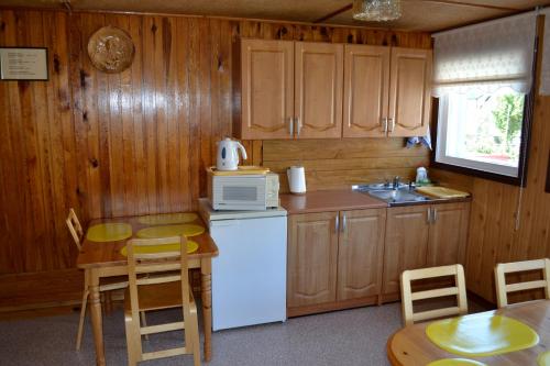 a kitchen with a white refrigerator and a table at Nooruse Majutus in Kuressaare