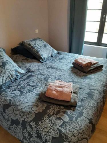 - un lit avec 2 serviettes assises au-dessus dans l'établissement LA DEMEURE DE CONSTANCE, à Saint-Martial-de-Nabirat