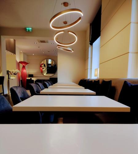 a row of tables in a room with chairs at Hotel Hamburger Hof in Frankfurt/Main