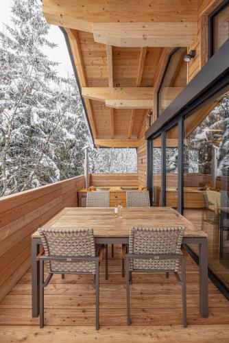 a wooden table on the deck of a house at Kronhofer – Apartments & Erlebnis-Imkerei in Hermagor