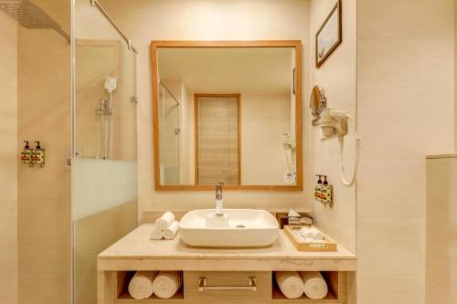 a bathroom with a sink and a shower at Lemon Tree Premier, Bhubaneswar in Bhubaneshwar