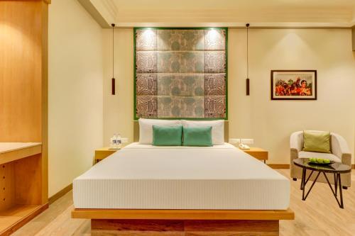 a bedroom with a bed and a chair at Lemon Tree Premier, Bhubaneswar in Bhubaneshwar