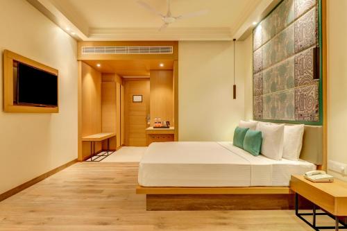 a hotel room with a bed and a television at Lemon Tree Premier, Bhubaneswar in Bhubaneshwar