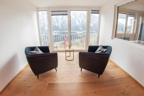 a living room with two chairs and a mirror at Alpenblick de Luxe in Oetz