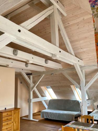 a loft with a blue couch in a room with wooden ceilings at Czarna Jachta - Na szlaku legend - - - - - Pokoje nad jeziorem in Kruklanki