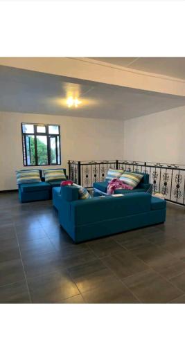 two blue couches sitting in a living room at Sunrise Sensation holiday home. in Centre de Flacq