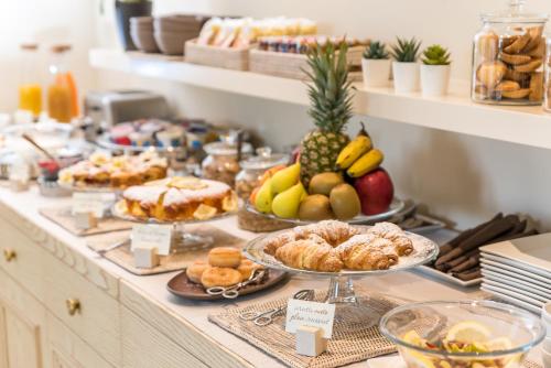 a buffet filled with different types of pastries and fruit at Hotel & Residence Exclusive in Marina di Carrara