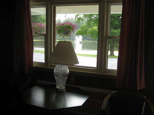 una lámpara sentada en una mesa frente a una ventana en Fountain View Motel, en Richfield Springs