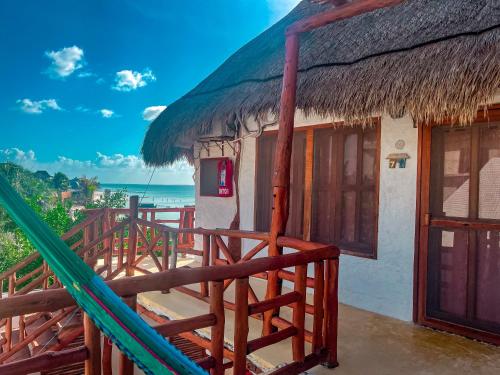 Casa con techo de paja y hamaca al aire libre en Golden Paradise Beach en Holbox Island