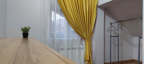 a yellow curtain in a room next to a window at Central Palace Iași Apart in Iaşi