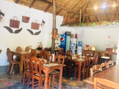 a dining room with wooden tables and chairs at RedDoorz Hostel @ Deomar Hometel & Farm Cafe Ilocos Sur in Bantaoay