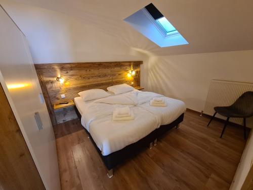a bedroom with a large bed with two towels on it at Hotel Pension Annerlhof in Maria Alm am Steinernen Meer