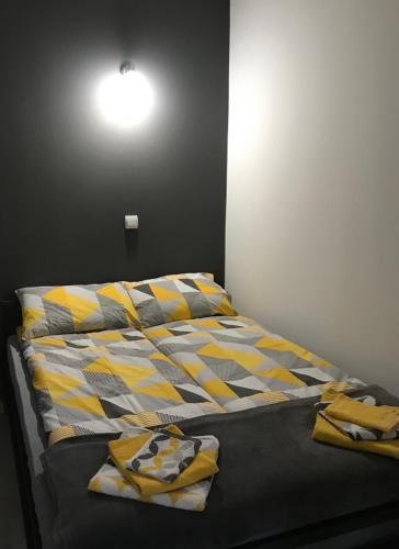 a bed with yellow and gray pillows on it at Aphrodite Hills Apartments-Stara Planina in Crni Vrh