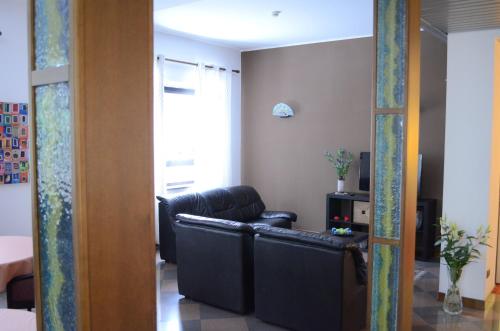 a living room with a black leather couch in a room at Hotel Adria in Mestre