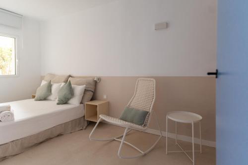 a bedroom with a bed and a chair and a table at JUST EXPERIENCE MALLORCA in Andratx