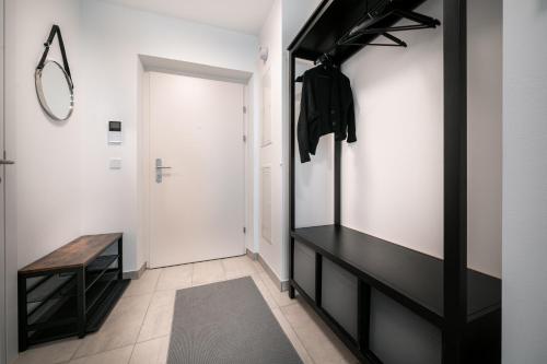 a hallway with a black console table and a mirror at Das Conrad by Schladming-Appartements in Schladming