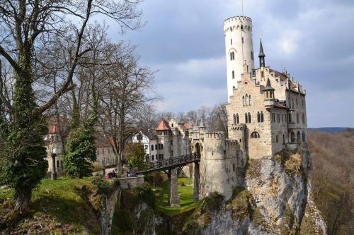 a castle on a cliff with a bridge in front of it at Exklusive Ferienwohnung m. Terrasse, ruhig gelegen in Pfullingen