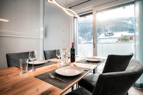 a dining room table with chairs and a bottle of wine at Das Conrad by Schladming-Appartements in Schladming
