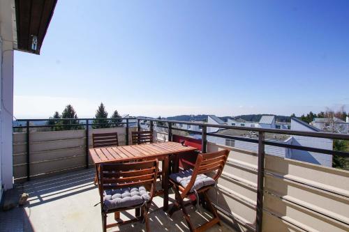 uma varanda com uma mesa de madeira e 2 cadeiras em Charmante Ferienwohnung mit Sauna und Schwimmbad im zauberhaften Bayerischen Wald em Sankt Englmar