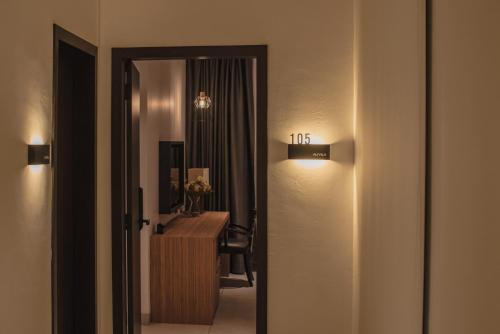 a hallway with a room with a desk and a mirror at Alivila in Muar