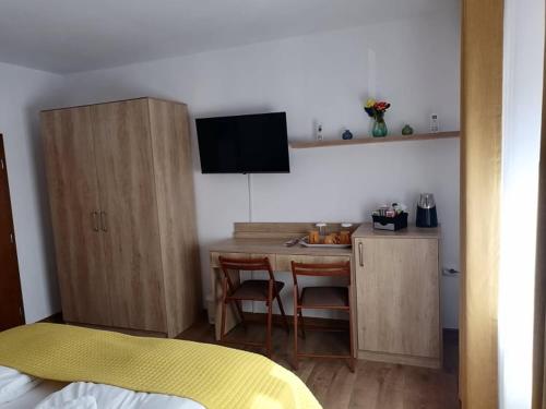 a room with a kitchen with a table and a desk at Happy House in Hunedoara