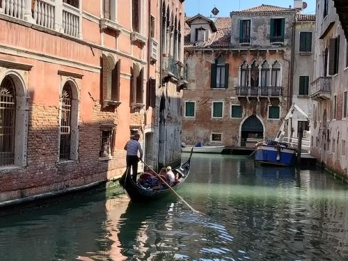 a man rowing a gondola in a canal at Apartment Rigoletto San Marco Square in Venice