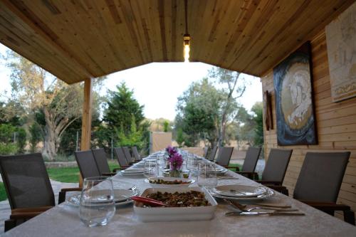 a long table with glasses and a bowl of food at Bir Dem Urla in Urla
