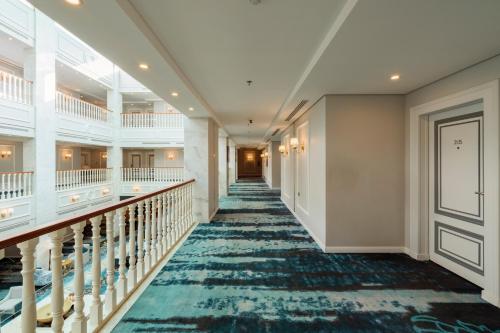 ウナイザにあるGulanar Hotelの青いカーペットが敷かれた階段のある建物の廊下