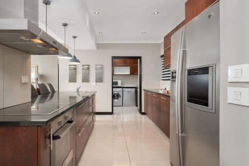 a kitchen with a refrigerator, stove, sink and microwave at Icon Luxury Apartments in Cape Town