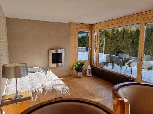 - un salon avec un lit et une grande fenêtre dans l'établissement Apartment in the heart of Crans Montana, à Crans-Montana