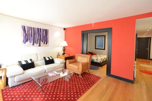 a living room with a white couch and a red wall at Go Donosti Jane in Donostia-San Sebastián