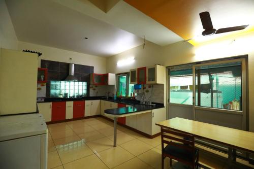 a kitchen with red and white cabinets and a table at The Ideal Nest Kumbakonam in Kumbakonam