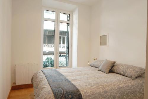 1 dormitorio con 1 cama grande y ventana grande en Go Donosti Zen, en San Sebastián