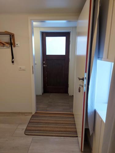 a door leading into a hallway with a rug at Grásteinn Guesthouse in Þórshöfn