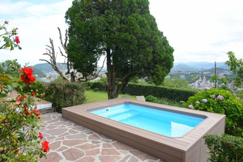 einen Pool in einem Garten mit Blumen in der Unterkunft Go Donosti Romanticismo in San Sebastián