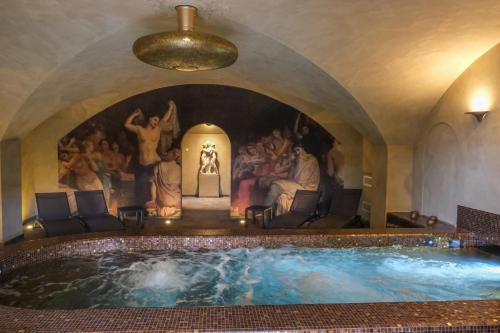 a large swimming pool in a room with a painting at Hôtel Restaurant Spa Le Sauvage in Besançon