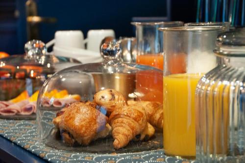 パリにあるHôtel Petit Saint-Honoréの食べ物とオレンジジュースのトレイ付きテーブル