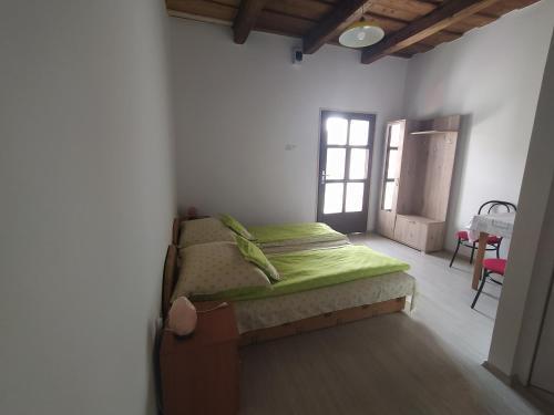 a bedroom with a bed in the corner of a room at Heni Vendégháza in Vadna