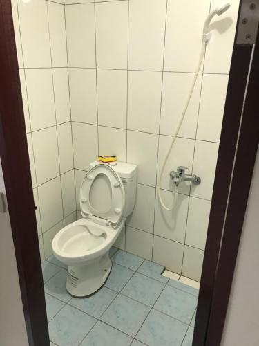 a bathroom with a toilet with the seat up at Sun Moment 鬆貓們民宿 in Toucheng