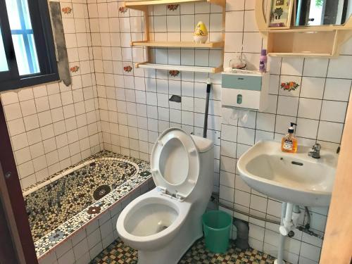a bathroom with a toilet and a sink at Sun Moment 鬆貓們民宿 in Toucheng
