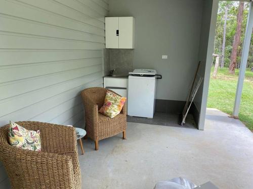 a patio with two chairs and a white refrigerator at Rural Self Contained 3 bedroom Cottage on acreage, in Landsborough