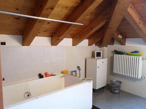 a kitchen with a white tub in a room with wooden ceilings at POETI&MISùLTIN. POESIA E VACANZA SUL LAGO in Menaggio