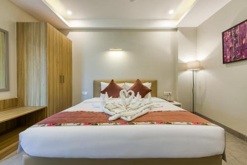 a bedroom with a bed with two towels on it at ROSASTAYS Gurugram Sec 31 in Gurgaon