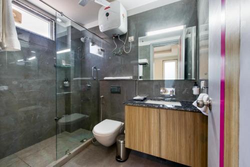 y baño con ducha, aseo y lavamanos. en ROSASTAYS Gurugram Sec 31, en Gurgaon