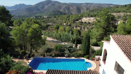 a villa with a swimming pool and mountains in the background at Casa Romero in Lliber