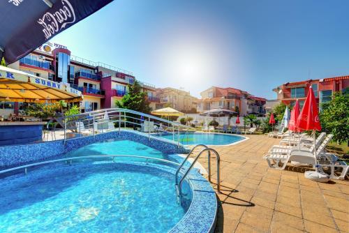 a swimming pool in a resort with chairs and umbrellas at Hotel Sunny in Sozopol