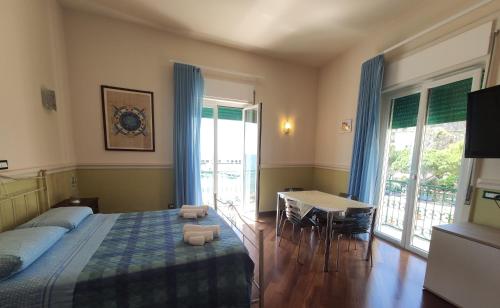 a bedroom with a bed and a table and a desk at Casa Angelica Cetara Albergo Diffuso in Cetara