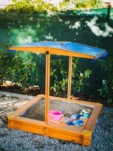 a wooden sandbox with some toys in the sand at A MI KISHÁZUNK vendégház in Szomód