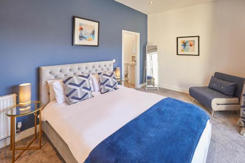 a bedroom with a large bed and a blue wall at Host & Stay - West Cliff Retreat in Whitby